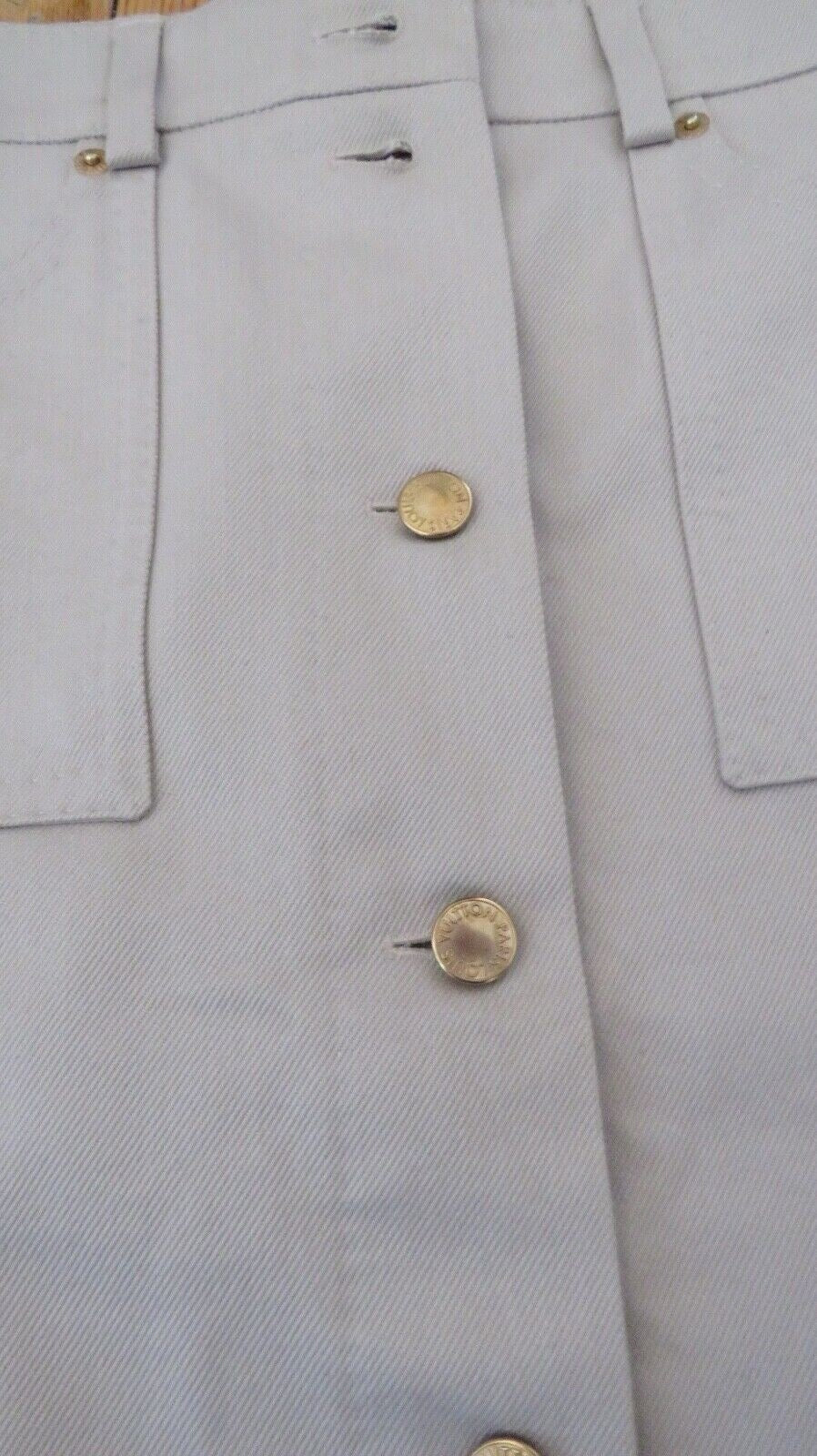 Louis Vuitton pencil skirt gold LV-branded snap buttons close-up