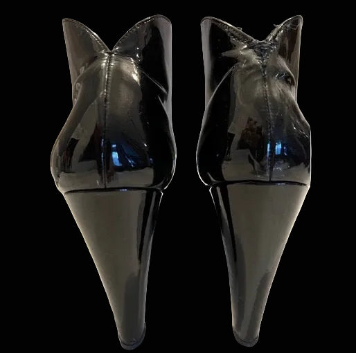 Miu Miu black patent leather ankle boots rear view showing curved cone heel architecture