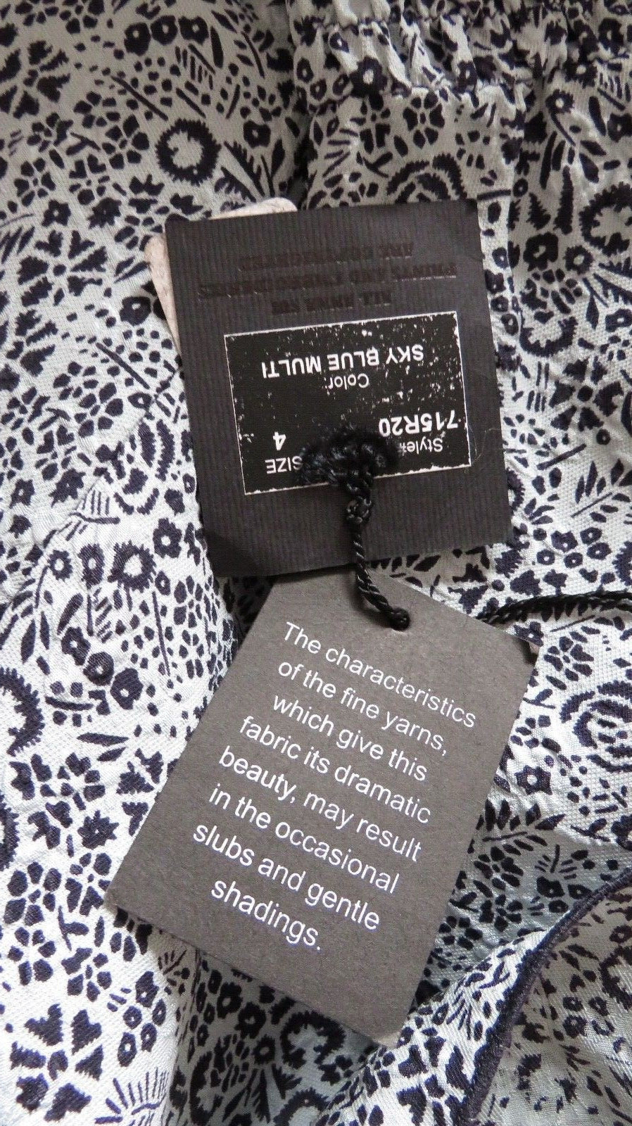 Anna Sui blue and white floral silk dress fabric and hang tag close up