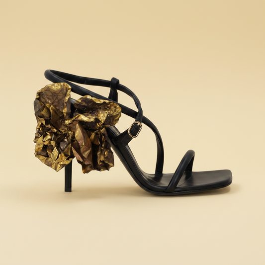 Bruno Frisoni — Black Leather Stiletto Sandals with Gold Flower — editorial black background