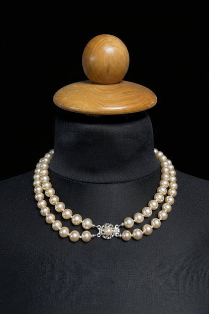 Vintage pearl necklace on display form